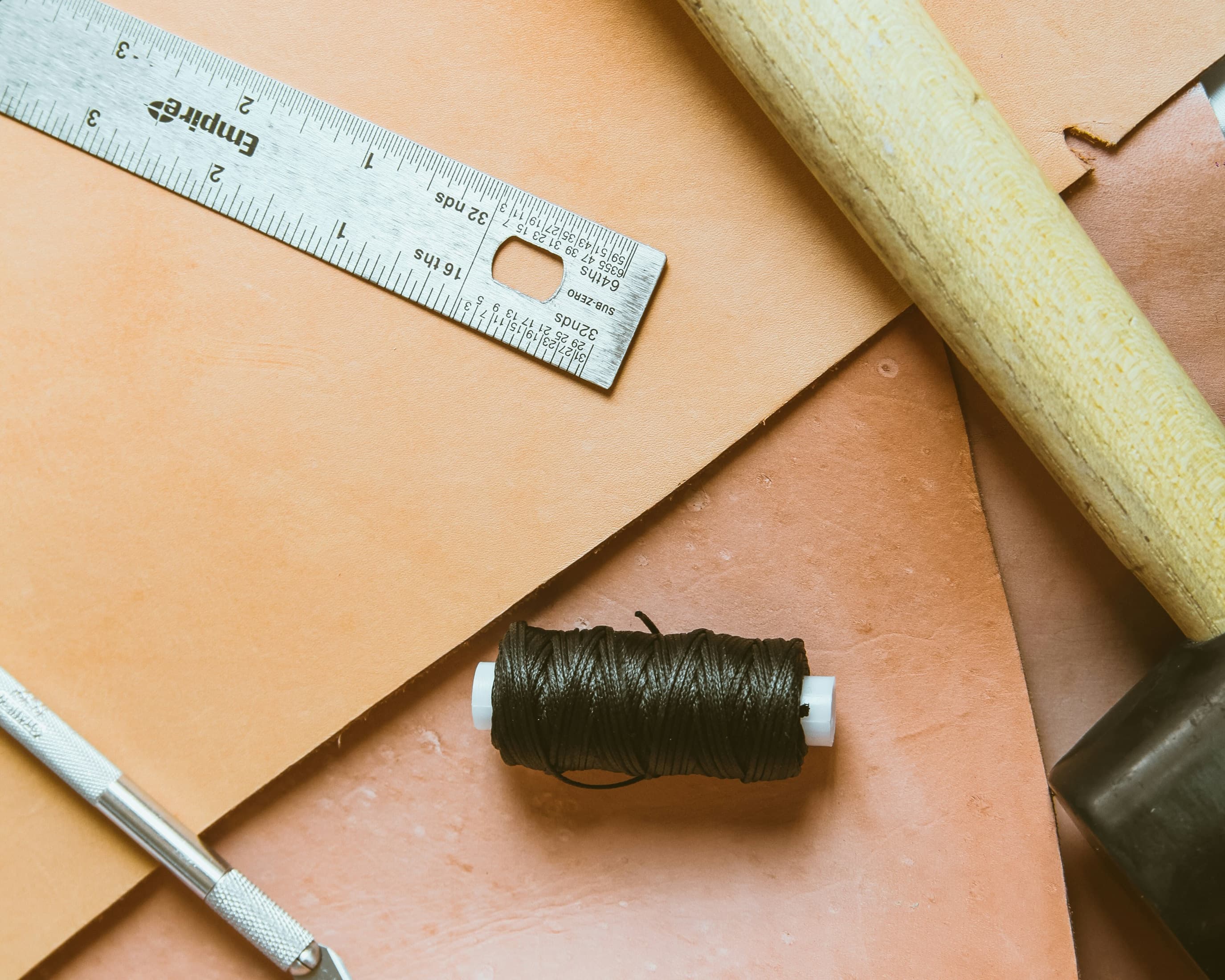 Outils de couture sur une table en cuir beige clair