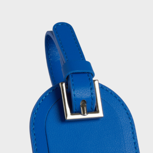 Étiquette de bagage bleu avec boucle argentée et couture soignée