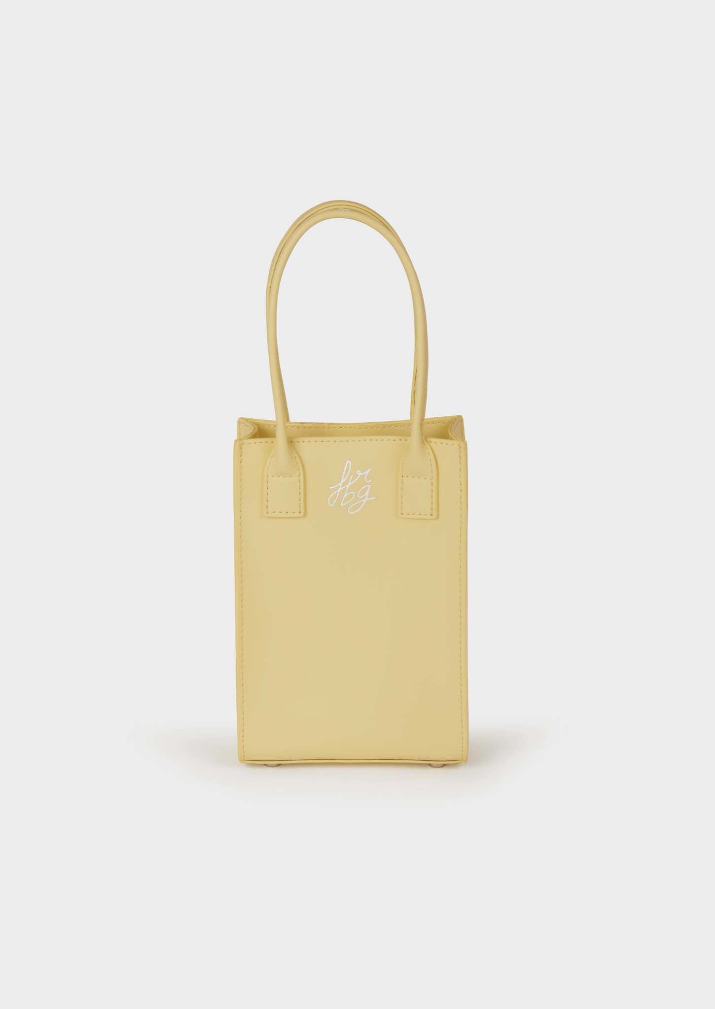 Un sac à main rectangulaire jaune pastel avec deux poignées 