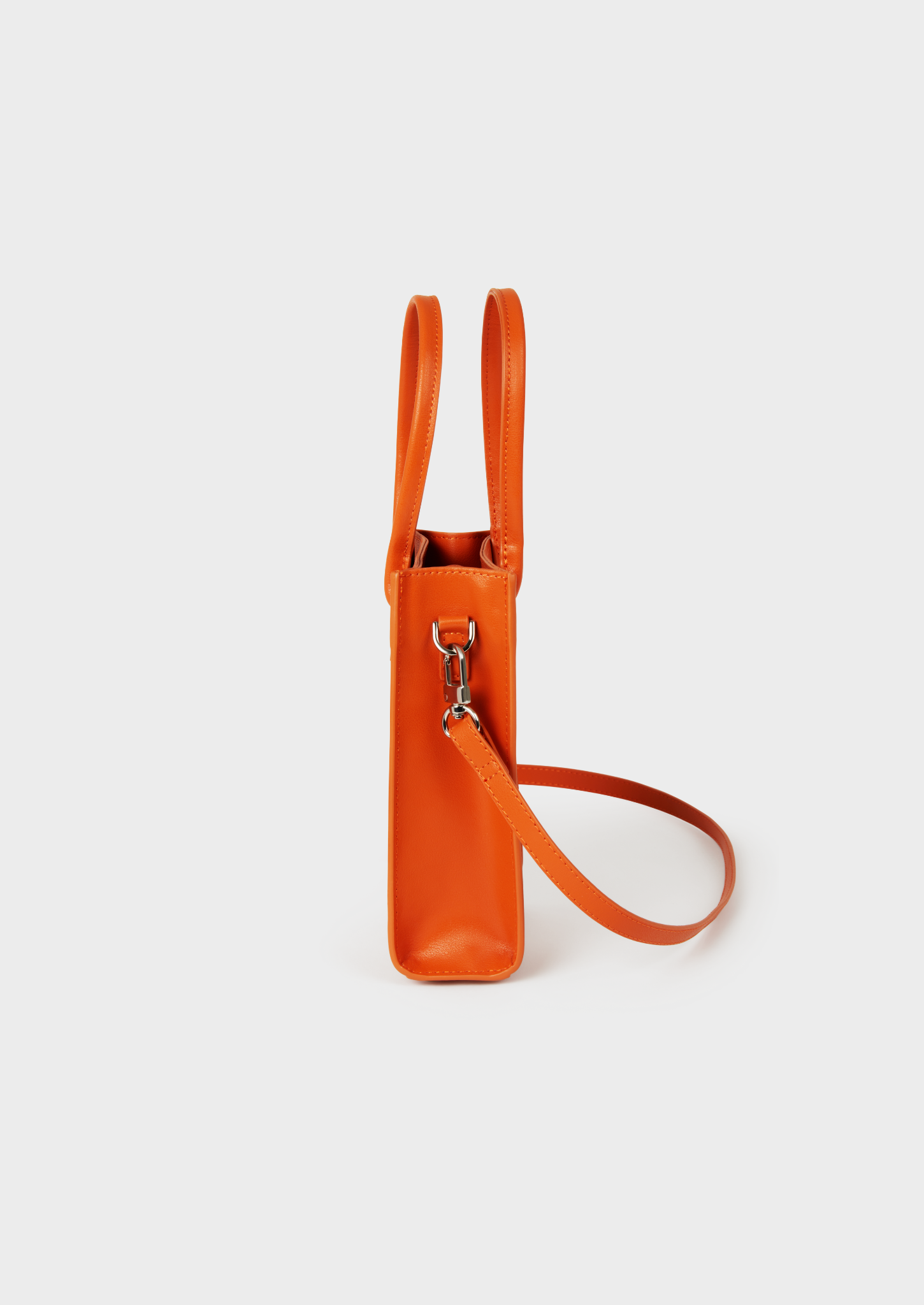 Petit sac orange en cuir, avec bandoulière et attache métallique