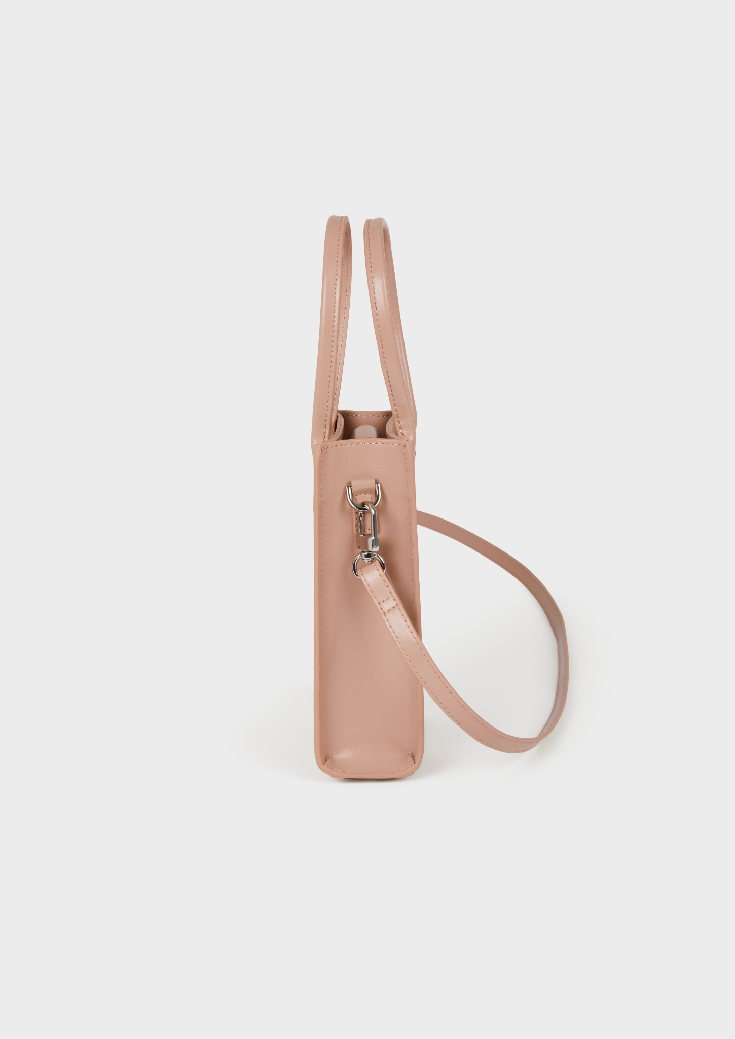 Petit sac rose clair en cuir, avec bandoulière et attache métallique